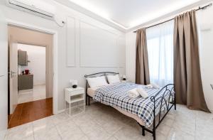 una camera da letto bianca con un letto e una finestra di Smile Suite in Milan a Milano