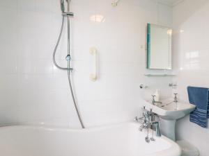 a white bathroom with a tub and a sink at Daisy Cottage in Perranporth +22 photos