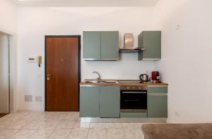una cucina con armadi verdi e lavandino di Smile Suite in Milan a Milano