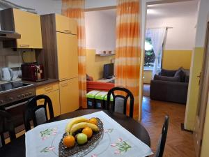 a kitchen and a table with a plate of fruit on it at Idila in Izola