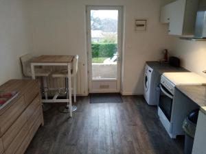 a small kitchen with a table and a window at Le Gîte de Lyli in LʼIsle-Jourdain
