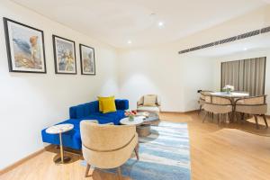 a living room with a blue couch and a table at Golden Tulip Jaipur City Center in Jaipur