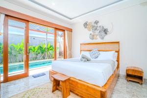 a bedroom with a large bed and a pool at Cozy 2BR Villa May II near Pererenan Beach in Cemagi +29 photos