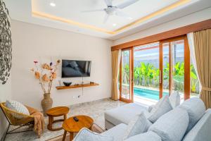 a living room with a couch and a tv at Cozy 2BR Villa May II near Pererenan Beach in Cemagi