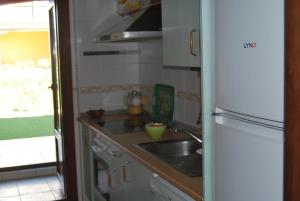 una pequeña cocina con fregadero y nevera. en Apartamento EL PARAÍSO, en Ayamonte