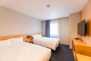 Postel nebo postele na pokoji v ubytování Sotetsu Fresa Inn Nagano-Ueda