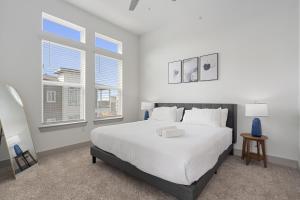 a white bedroom with a large bed and two windows at Luxury Apartments Near Airport in Austin +78 photos