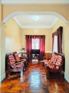 a living room with two couches and red curtains at RKC Guest House in Coron