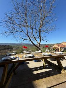 a wooden picnic table with plates and wine glasses at Casona el mirador de toporias in Toporías