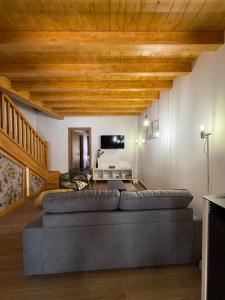 a living room with a large couch and wooden ceilings at Casona el mirador de toporias in Toporías