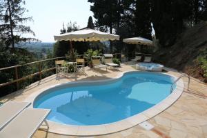 einen großen blauen Pool mit Stühlen und einem Tisch in der Unterkunft Villa Alta - Residenza d'epoca con piscina in San Giuliano Terme