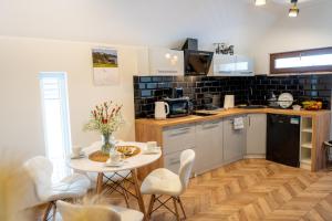 a kitchen with a table and chairs and a table and a kitchen with a counter at Górski Azyl Apartament Kluszkowce in Kluszkowce