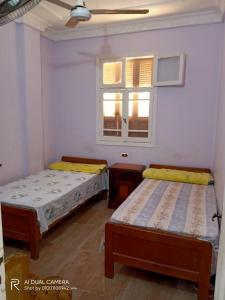 two beds in a room with two windows at شقة مفروشة للايجار فى راس البر سادس مطل من البحر in Ras El Bar