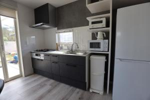 a kitchen with a sink and a microwave at ナミハラシークレット in Minamiboso
