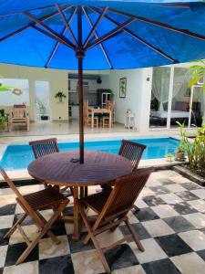 a table with an umbrella in front of a pool at Villa WENHOMANN in Lovina