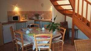 a kitchen with a table and chairs and a staircase at Ferme de Poulpeye in Loctudy