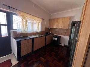 a small kitchen with a sink and a refrigerator at Our Home Guest House in Bellville