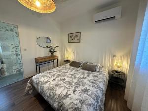 a bedroom with a bed and a table and a lamp at Maison de vacances in Gondrin