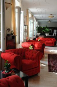 a living room with red couches in a room at Hotel Riviera Varazze in Varazze