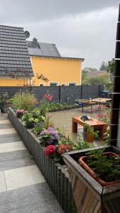 a garden with flowers and a table on a patio at Ferienwohnung mit Balkon in Lauchhammer