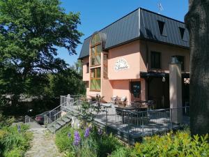 a pink building with a table and chairs in front of it at Penzion Janata in Slapy