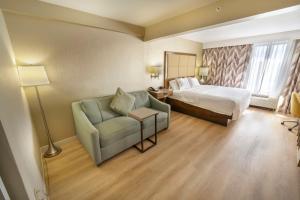 a hotel room with a bed and a chair at Hampton Inn Jacksonville South/I-95 at JTB in Jacksonville +49 photos
