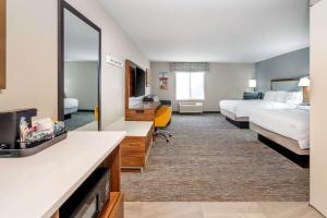 une chambre d'hôtel avec deux lits et un miroir dans l'établissement Hampton Inn Mitchell, à Mitchell 30 autres photos