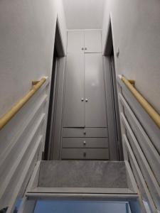 a walkway in a closet with white cabinets and a door at Luxury Angel Apartments 3 in Paralia Katerinis
