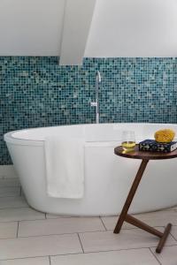 a bath tub in a bathroom with a table at The Merchant in Salem