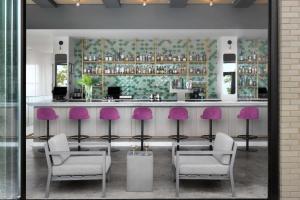 a bar with purple chairs in a room at Angad Arts Hotel St Louis, Tapestry Collection by Hilton in Saint Louis
