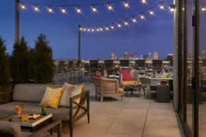 a rooftop patio with a view of the city at night at Angad Arts Hotel St Louis, Tapestry Collection by Hilton in Saint Louis