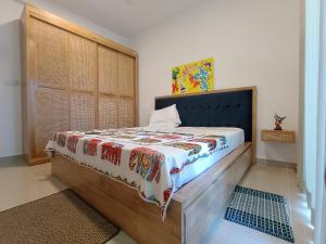 尼甘布Santorini Resort Art Of Living Apartment Negombo 48的卧室里有一张床，床上有一条毯子 更多44张照片