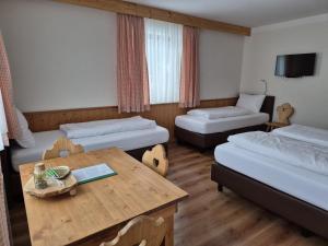 een hotelkamer met twee bedden en een tafel bij Gästehaus Zum Steirischen Kuss in Aich
