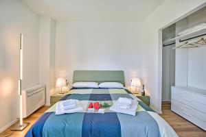 a bedroom with a bed with towels and flowers on it at Tintoretto Apartments in Lido di Camaiore