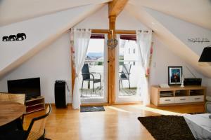 a living room with an open door to a balcony at Sonniges Familien-Nest im Allgäu in Hergatz