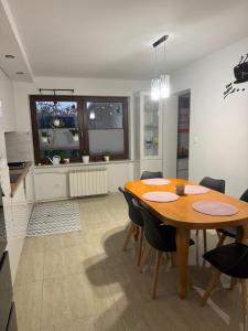 a kitchen and dining room with a wooden table and chairs at Oaza Spokoju in Augustów +11 photos