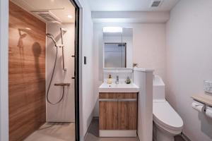 a bathroom with a toilet and a sink and a shower at Apartment Hotel 11 Shinsaibashi 5 in Osaka