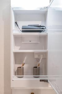 an open refrigerator with two utensils in it at Apartment Hotel 11 Shinsaibashi 5 in Osaka