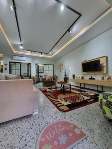 un soggiorno con un divano e una TV di Villa Lotus Palagan Yogyakarta a Kejayan