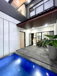 una casa con piscina e pianta in vaso di Villa Lotus Palagan Yogyakarta a Kejayan