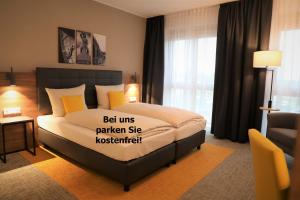Un dormitorio con una cama con un cartel. en Hotel INCLUDiO, en Regensburg