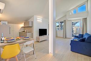 a living room with a table and a blue couch at Tintoretto Apartments in Lido di Camaiore