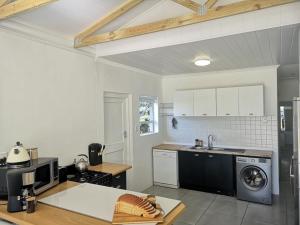 a kitchen with a sink and a washer and dryer at Hartsepunt in Mossel Bay