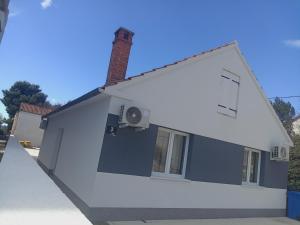 a blue and white building with a chimney at Villa Adriatic 2 in Biograd na Moru