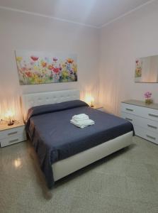 Un dormitorio con una cama y dos cómodas y un cuadro. en Appartamento Cuore, en San Pietro Vernotico