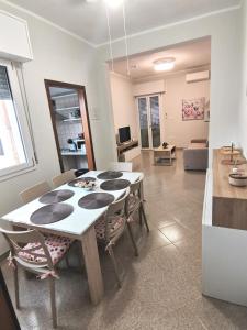 mesa de comedor con sillas y sala de estar. en Appartamento Cuore, en San Pietro Vernotico