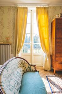a room with a couch in front of a window at Château de Choloy in Choloy