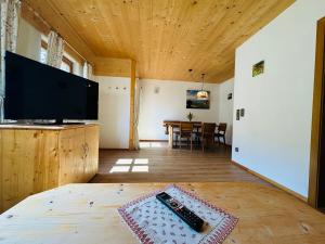 a living room with a television and a table at Ferienwohnung Beim Raffner, Bergblick, Natur, Ruhpolding in Ruhpolding