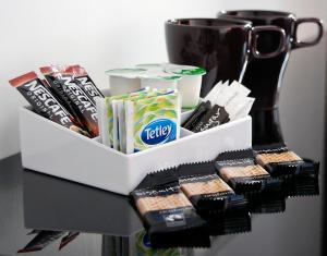 a black table with a tray of snacks and a cup at Miller House Courtyard in Ayr