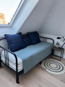 a bed with blue pillows in a room at Zum Schwedenblick in Zingst